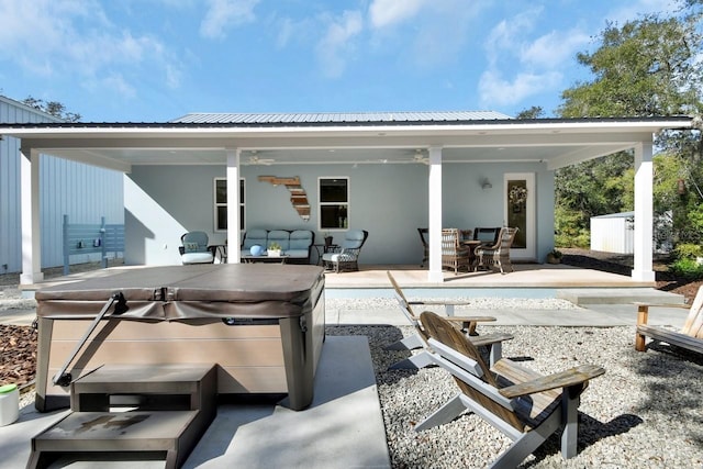 back of house featuring a hot tub, outdoor lounge area, and a patio area