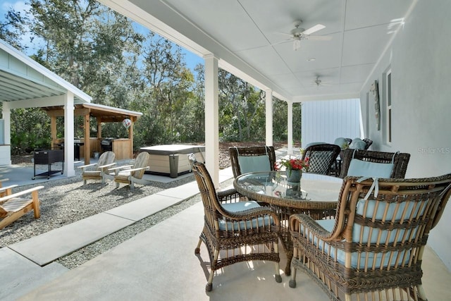 view of patio / terrace with ceiling fan and a hot tub