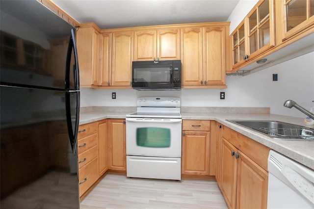 kitchen with light brown cabinetry, sink, black appliances, and light hardwood / wood-style floors