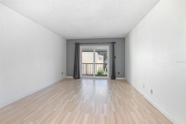 unfurnished room with a textured ceiling and light wood-type flooring