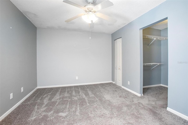 unfurnished bedroom with ceiling fan, two closets, carpet, and a textured ceiling