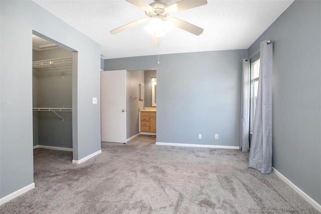 unfurnished bedroom with light carpet, a textured ceiling, ceiling fan, and a closet