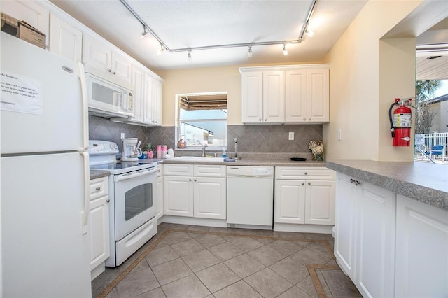 kitchen featuring white cabinetry, light tile patterned floors, backsplash, and white appliances