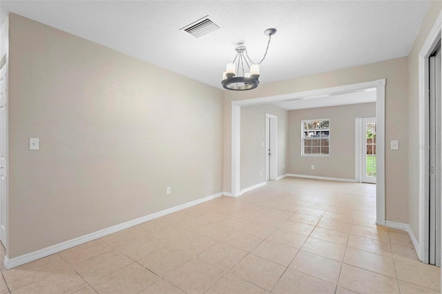 unfurnished room with light tile patterned flooring and a chandelier