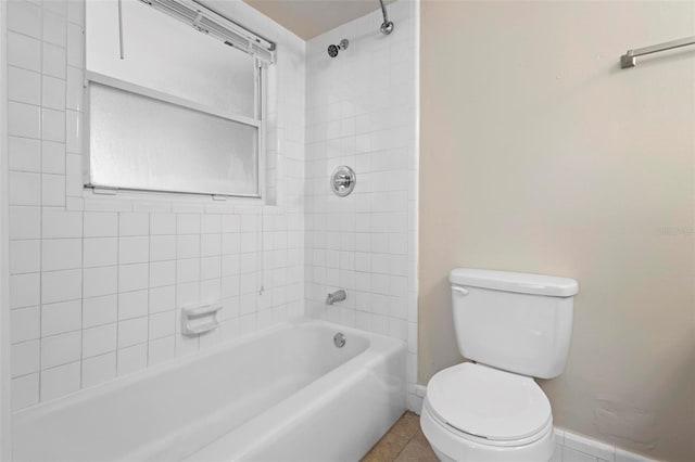 bathroom featuring tiled shower / bath combo, tile patterned floors, and toilet