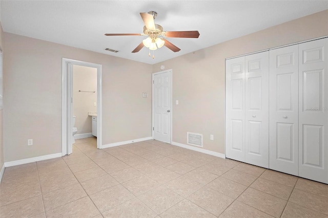 unfurnished bedroom featuring ceiling fan, a closet, ensuite bath, and light tile patterned floors