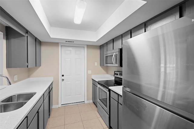 kitchen with gray cabinetry, appliances with stainless steel finishes, sink, and light tile patterned floors