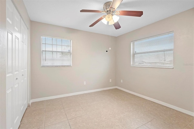 unfurnished bedroom featuring light tile patterned flooring, ceiling fan, and a closet