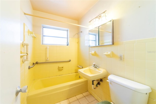 bathroom featuring tiled shower / bath, plenty of natural light, tile patterned floors, and toilet