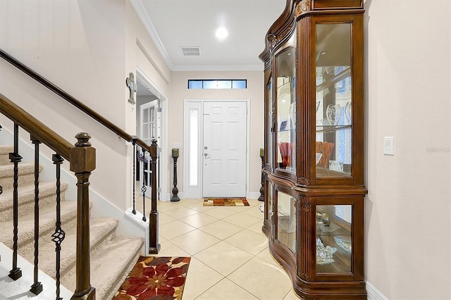 foyer with light tile patterned floors and ornamental molding