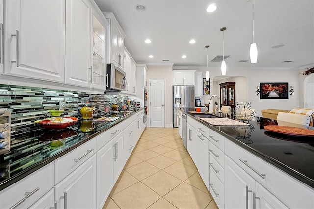 kitchen with sink, light tile patterned floors, appliances with stainless steel finishes, white cabinetry, and decorative light fixtures