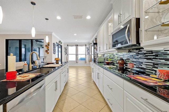 kitchen featuring ornamental molding, appliances with stainless steel finishes, sink, and white cabinets