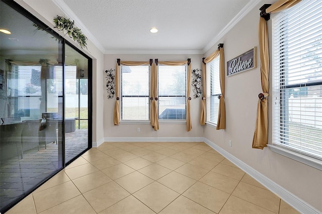 empty room featuring light tile patterned floors, crown molding, and a textured ceiling