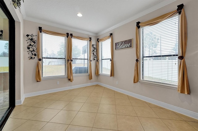 unfurnished room with light tile patterned floors, crown molding, and a textured ceiling