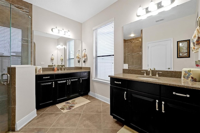 bathroom with tile patterned flooring, vanity, and a shower with shower door