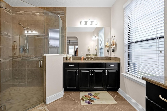 bathroom featuring tile patterned flooring, vanity, a shower with door, and ceiling fan