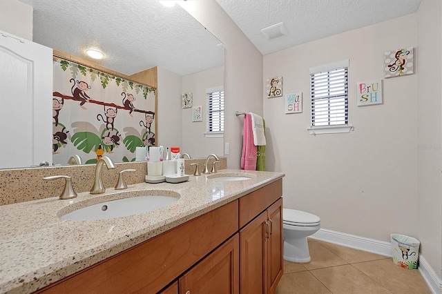 bathroom with vanity, tile patterned floors, a textured ceiling, and toilet