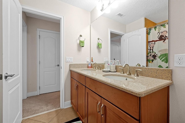 bathroom featuring vanity, tile patterned flooring, and a textured ceiling