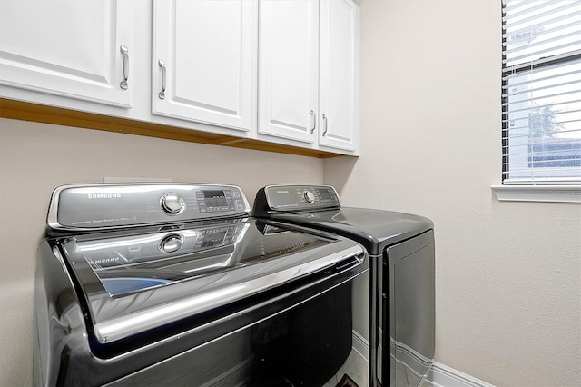 washroom with cabinets and washer and clothes dryer