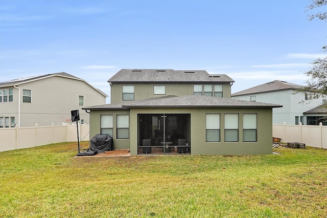 back of house with a sunroom and a lawn