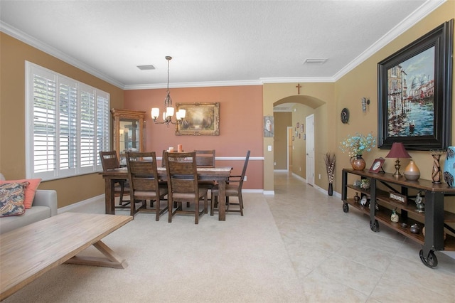 dining area with ornamental molding, a textured ceiling, and an inviting chandelier