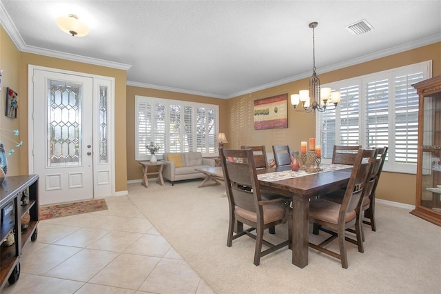 carpeted dining room with crown molding and an inviting chandelier