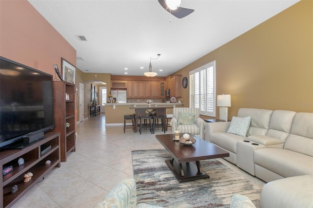 tiled living room with ceiling fan