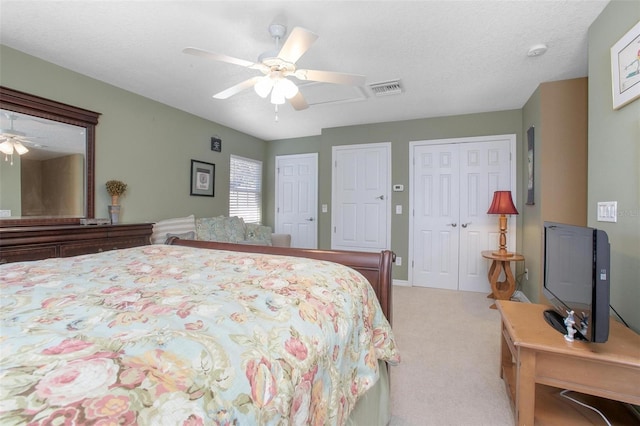 bedroom with light carpet, a textured ceiling, and ceiling fan