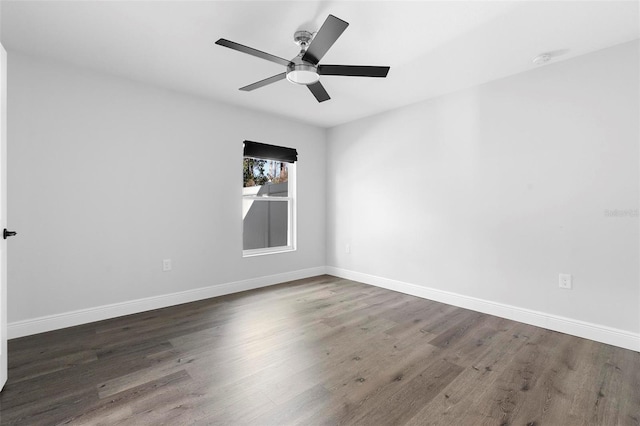 empty room featuring dark wood-type flooring and ceiling fan