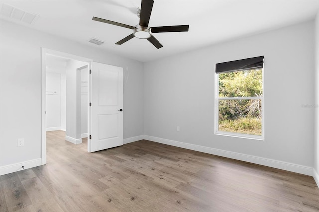 spare room with ceiling fan and light wood-type flooring