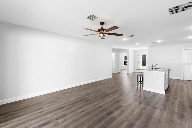 unfurnished living room featuring dark hardwood / wood-style flooring, sink, and ceiling fan