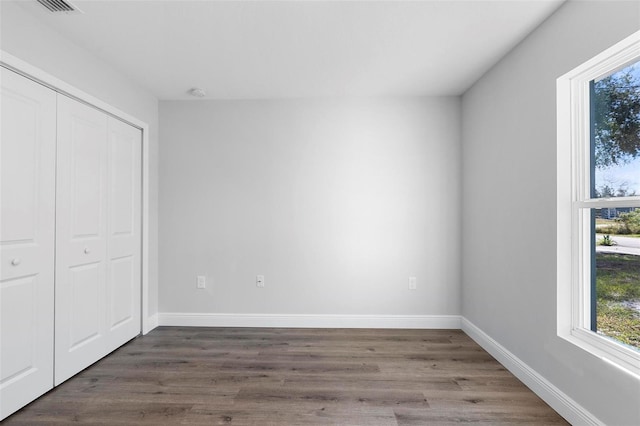 unfurnished bedroom featuring dark wood-type flooring and a closet