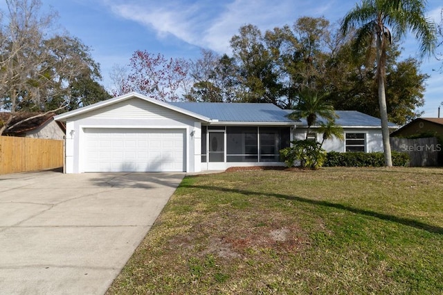 single story home featuring a garage, a sunroom, and a front yard