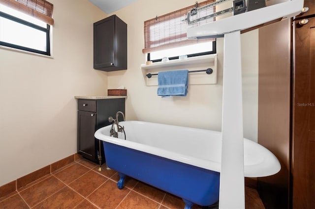 bathroom with a tub to relax in and tile patterned flooring