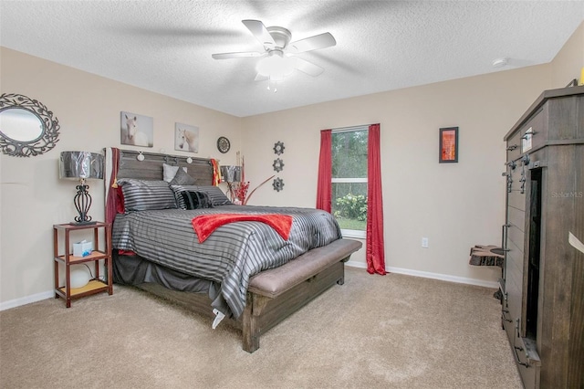 bedroom featuring ceiling fan, light colored carpet, and a textured ceiling