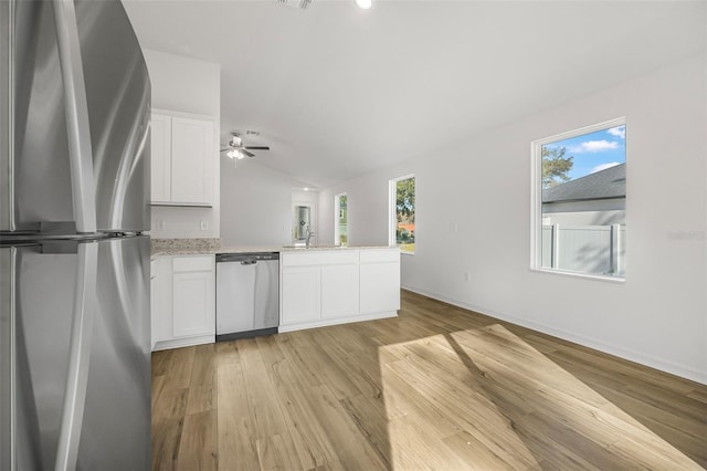 kitchen with white cabinetry, stainless steel appliances, kitchen peninsula, and light hardwood / wood-style floors