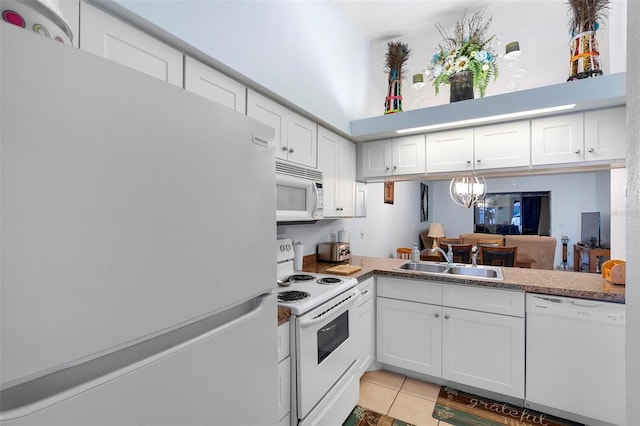 kitchen with light tile patterned flooring, sink, white cabinets, and white appliances