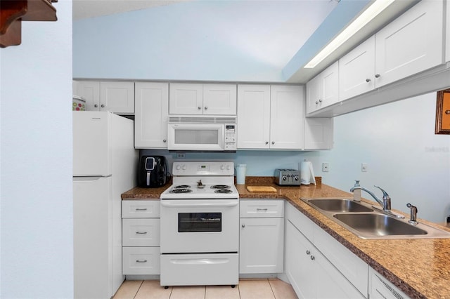 kitchen with white cabinetry, sink, white appliances, and light tile patterned flooring