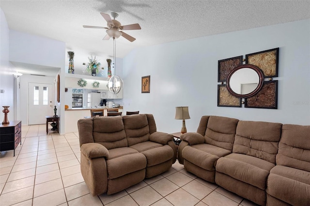 living room featuring light tile patterned flooring, ceiling fan, and a textured ceiling