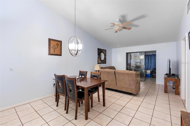 dining space with ceiling fan with notable chandelier, vaulted ceiling, and light tile patterned flooring