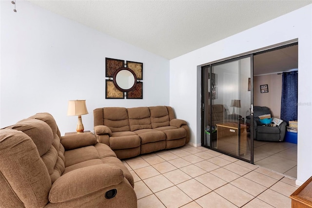 tiled living room featuring vaulted ceiling and a textured ceiling