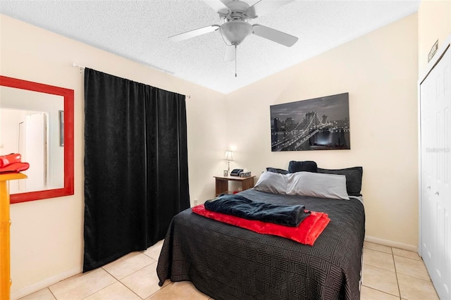 bedroom with lofted ceiling, light tile patterned floors, ceiling fan, and a closet