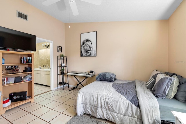 bedroom with ensuite bath, vaulted ceiling, ceiling fan, and light tile patterned flooring