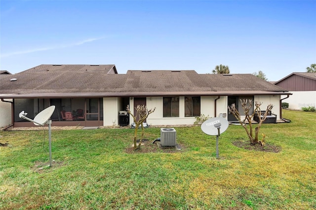 back of property featuring a sunroom and a lawn