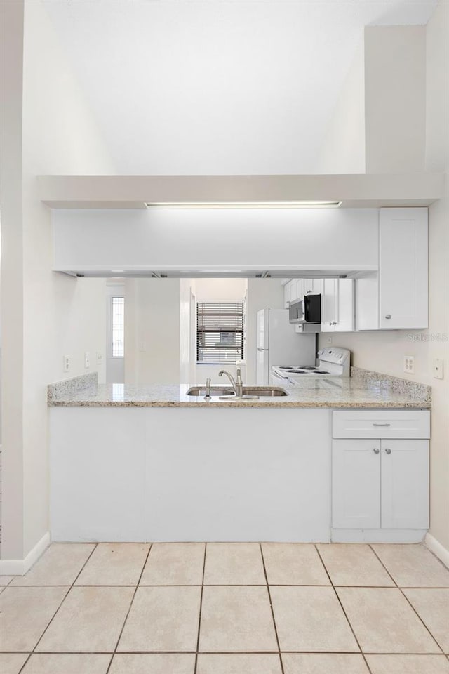 245 Terrace Hill Blvd Unit 1E, Debary, FL 32713 - kitchen featuring white appliances, light stone counters, white cabinetry, light tile patterned floors, and high vaulted ceiling