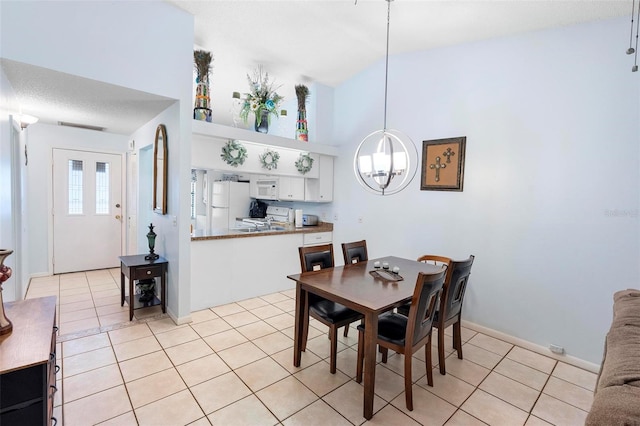 245 Terrace Hill Blvd Unit 1E, Debary, FL 32713 - dining space featuring a chandelier, light tile patterned flooring, and high vaulted ceiling