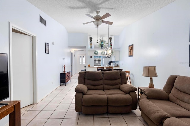 245 Terrace Hill Blvd Unit 1E, Debary, FL 32713 - living room featuring light tile patterned flooring, a ceiling fan, a chandelier, a textured ceiling, and vaulted ceiling