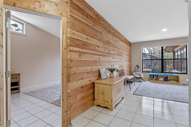 interior space with wooden walls and light tile patterned floors