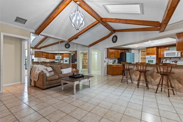 living room with a notable chandelier, vaulted ceiling with beams, and light tile patterned flooring