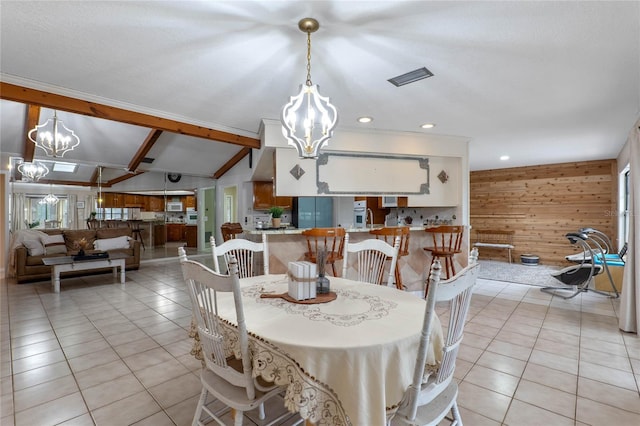 dining area featuring an inviting chandelier, wooden walls, light tile patterned flooring, and lofted ceiling with beams